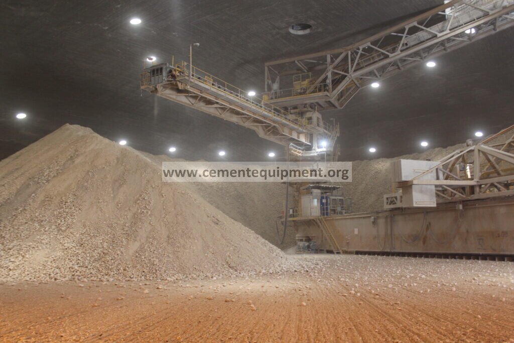 Cement plant stacker reclaimer with slewing boom and drive assembly above limestone stockpile, photographed at Nesher Ramla